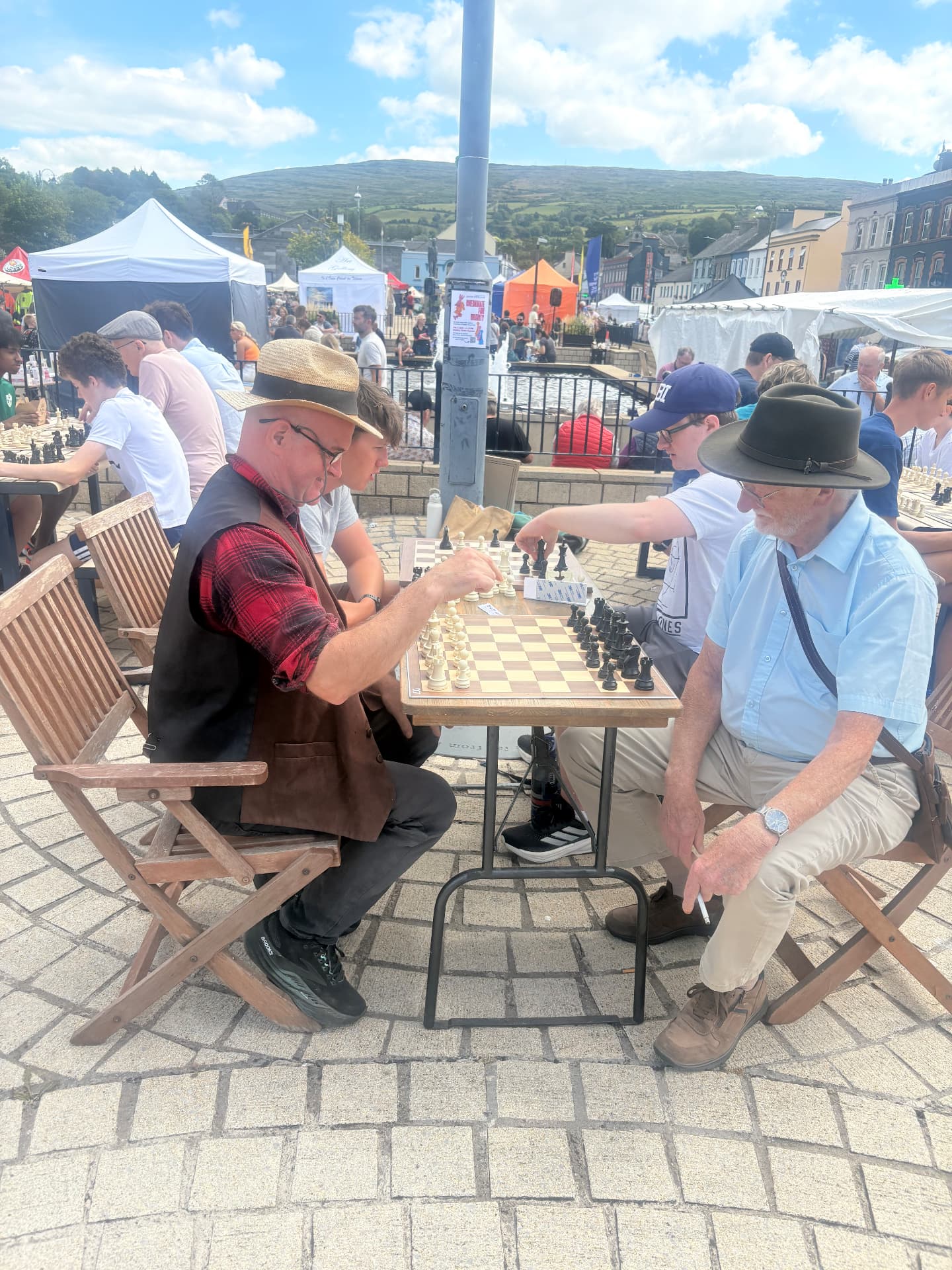 Simultaneous games in progress in front of the fountain at Checkmate for Charity in Bantry Town Square