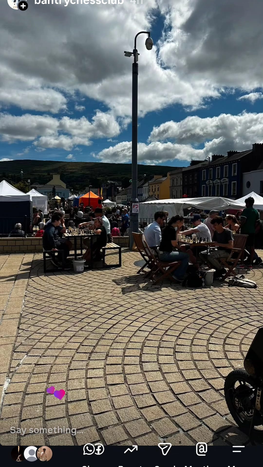 Wide view of the busy Checkmate for Charity event in Bantry Town Square with market stalls and chess boards