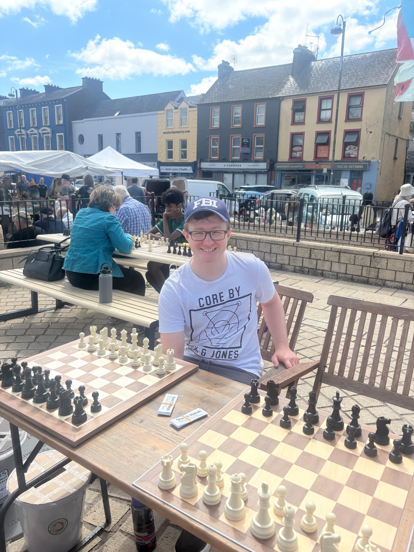 Club member seated at two chess boards ready for challengers at Checkmate for Charity in Bantry Town Square